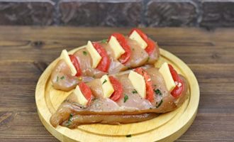 Khi thịt đã được ướp kỹ, bạn hãy rạch xiên sâu vào từng miếng phi lê rồi gói phô mai và cà chua vào như trong ảnh.