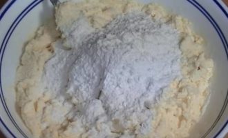 Thêm bột mì đã rây với bột nở vào, khuấy đều. Để trong 30 phút để các nguyên liệu hòa quyện với nhau và bạn sẽ có được những chiếc bánh phô mai mềm mịn trong chảo.