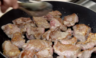 En una paella per preparar el goulash, escalfeu bé l'oli de gira-sol i fregiu els trossos de carn en farina fins que estiguin daurats.