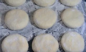 Tạo thành những chiếc bánh phô mai có cùng kích thước và độ dày để nướng đều.Đầu tiên, cuộn các quả bóng lại, sau đó dẹt thành những chiếc bánh dẹt dày không quá 1-1,5 cm, đặt những chiếc bánh kếp phô mai tươi lên một tấm thớt có rắc bột mì và từng chiếc bánh phô mai trong bột mì.