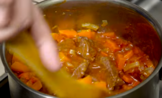 Afegiu-hi una cullerada de pasta de tomàquet a la carn de porc estofada en una paella (després d'una hora de guisat), afegiu-hi les verdures fregides i remeneu-ho suaument. Cuini el gulasch durant 30-40 minuts més amb la tapa tancada.