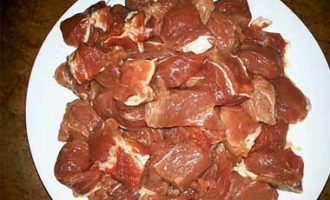 Hoe rundvleesgoulash met jus in een koekenpan koken volgens het klassieke recept? Verwijder de vliezen van de ossenhaas (bij voorkeur de nek of schouder) en snij in blokjes met een zijde van ongeveer 3 cm.Houd er rekening mee dat het vlees volledig ontdooid moet zijn.