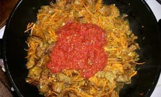 Doe de tomatenpuree in een koekenpan, gevolgd door de knoflook en kruiden. U kunt alle smaakmakers kiezen die naar uw mening goed bij het vlees passen.