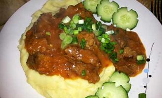Het is beter om aromatische rundvleesgoulash met jus in een koekenpan te serveren, samen met aardappelpuree en groenten.