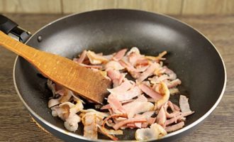 Helyezze a serpenyőt közepes lángra, és enyhén süsse a baconszeleteket aranybarnára 3 perc alatt.