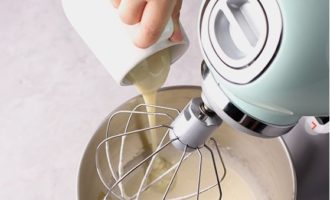 Đổ sữa đặc vào tô có hỗn hợp trứng, đánh thêm khoảng 1 phút. Thêm kem chua và đánh cho đến khi mịn.