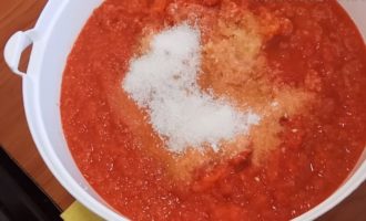 Häll strösocker, salt och vinäger i vitlök- och pepparblandningen och blanda ingredienserna noggrant. Observera att skålen med adjika ska vara av plast eller glas, men inte metall. Låt adjikaen dra i ungefär en timme och förbered burkarna med lock under denna tid.