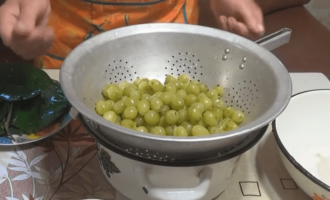 Sau đó, vớt lá anh đào ra một chiếc bát riêng, đặt quả dâu vào một cái chao và để ráo nước.