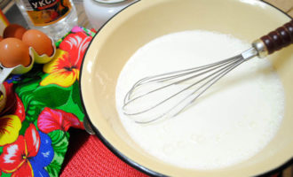 อุ่น kefir ตามจำนวนที่ต้องการเล็กน้อยเทลงในชามสำหรับนวดแป้งเติมโซดาเกลือเล็กน้อยน้ำตาลแล้วคนให้เข้ากัน จากนั้นตอกไข่สองฟองลงใน kefir แล้วผสมทุกอย่างโดยใช้เครื่องผสมหรือที่ตี
