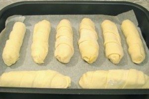 Đặt xúc xích vào bột trên khay nướng có lót giấy da và cho vào lò nướng trong 30-40 phút. Nhiệt độ nướng - 180 độ. Để làm cho bề mặt bột sáng bóng, bạn có thể phết xúc xích lên trên bằng lòng đỏ trứng sống.