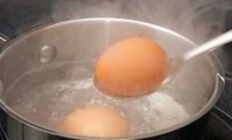 Com preparar delicioses tartaletes farcides per a la taula de vacances? Col·loqueu els ous en una cassola petita, aboqueu-hi prou aigua freda per cobrir els ous completament i poseu la cassola al foc. Quan l'aigua bulli, reduïu una mica el foc i coeu els ous de gallina durant 10 minuts. Quan hagi passat el temps especificat, submergiu els ous bullits en aigua freda durant 5-10 minuts. Després d'aquestes manipulacions, pelar els ous no serà difícil: la closca es desenganxarà fàcilment. Traieu els rovells dels ous (no s'utilitzen en aquesta recepta) i ratlleu les clares amb un ratllador fi.