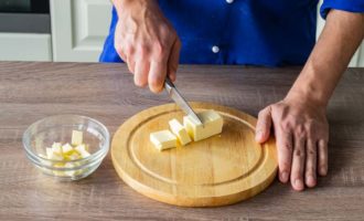 Hur gör man läckra mördegskakor hemma? Ta färskt smör och skär det i tärningar med en vass kniv. Lägg smöret i en lämplig behållare och ställ åt sidan så att det smälter. Detta tar dig ungefär en halvtimme.