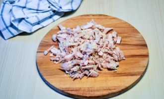 Apoi se răcește puiul și se despart carnea de oase. Dezasamblați carnea cu mâna în fibre (dacă sunt mari, le puteți tăia în jumătate cu un cuțit). Nu îl puteți separa în fibre, ci îl puteți tăia în cuburi mici - totul depinde de preferințele dvs. de gust.