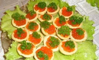 Col·loqueu amb cura la quantitat necessària de barreja de mantega i proteïnes a cada tartaleta i afegiu-hi 1 o 2 culleradetes de caviar vermell per sobre. Decoreu cada tartaleta amb una petita branca de julivert rentat i sec. Posa l'aperitiu resultant a la nevera abans de servir. Les tartaletes amb caviar s'han de servir a l'inici de la festa com a aperitiu en un plat decorat amb enciam fresc.