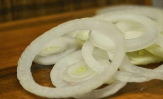 Cum să gătești cotlete de porc suculente într-o tigaie? Pentru început, luați ceapa și curățați-o de coajă. Apoi, după ce clătiți ceapa în apă cu gheață, tăiați legumele în inele sau jumătate de inele - după cum preferați.