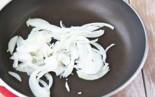 Peleu la ceba i talleu-la a mitges rondelles. En una paella amb oli vegetal, sofregiu la ceba per tots els costats fins que estigui tova. És millor triar foc mitjà.