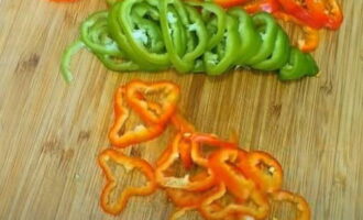 Verwijder de zaden met scheidingswanden en stengels van paprika's en snijd het vruchtvlees in dunne ringen. Paprika's kunnen in verschillende kleuren worden genomen. Verwijder de zaden met scheidingswanden en stengels van paprika's en snijd het vruchtvlees in dunne ringen. Paprika's kunnen in verschillende kleuren worden genomen.