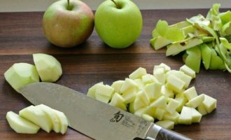 Làm thế nào để nướng bánh táo từ bánh phồng trong lò? Gọt vỏ táo và loại bỏ lõi và hạt. Cắt táo thành những khối nhỏ và đặt chúng vào một cái bát riêng.