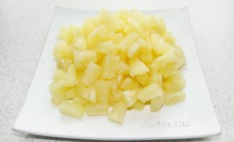 Escorreu el suc de les pinyes en conserva. Talleu les rodanxes de pinya a daus petits.