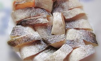 Vi skär den beredda slaktkroppen i medelstora bitar och separerar samtidigt benen. Lägg fiskfilén i en kokkärl.