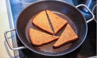 Pahiran ng langis ng gulay ang isang kawali at iprito ang mga piraso ng tinapay sa magkabilang panig hanggang sa bahagyang malutong (ngunit mag-ingat na huwag masunog). Susunod, kuskusin ang bawat hiwa sa isang gilid na may hiwa ng bawang.
