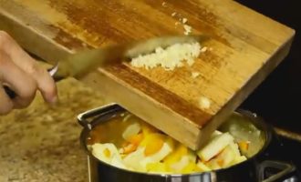 Tăiați tulpina cu semințe din ardeiul gras și spălați-o. Taiem si cubulete. O trimitem la legume. Apoi turnați usturoiul tocat cu un cuțit.