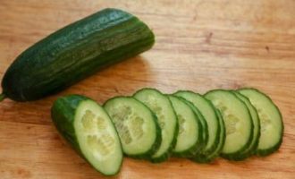 Gupitin ang hugasan na pipino sa manipis na hiwa.