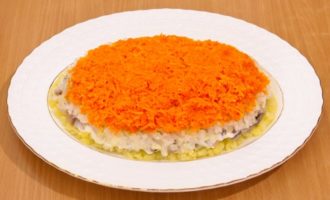 Al patrulea strat sunt ouăle, pe care le ungem cu un strat de maioneză.Al cincilea strat este morcovii strălucitori și dulci, care, la fel ca toate ingredientele anterioare, trebuie acoperiți cu maioneză.