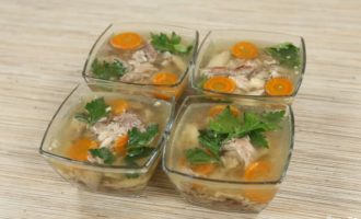 Het voorbereiden van de mallen voor de vulling. Het is beter als dit kleine transparante kommen zijn, dan zal al het moois duidelijk zichtbaar zijn. Bedek de bodem van de kommen met een kleine hoeveelheid bouillon, leg er een samenstelling van kipfilet, wortels en peterselieblaadjes op en giet de resterende bouillon in de kommen. Voordat u de aspic in de koelkast legt, moet u ervoor zorgen dat deze is afgekoeld tot kamertemperatuur. Het voorbereiden van de mallen voor de vulling. Het is beter als dit kleine transparante kommen zijn, dan zal al het moois duidelijk zichtbaar zijn. Bedek de bodem van de kommen met een kleine hoeveelheid bouillon, leg er een samenstelling van kipfilet, wortels en peterselieblaadjes op en giet de resterende bouillon in de kommen.Voordat u de aspic in de koelkast legt, moet u ervoor zorgen dat deze is afgekoeld tot kamertemperatuur.