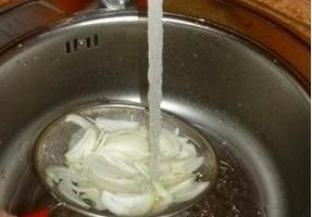 Poseu la ceba en un colador o colador i esbandiu bé amb aigua freda per eliminar l'amargor.
