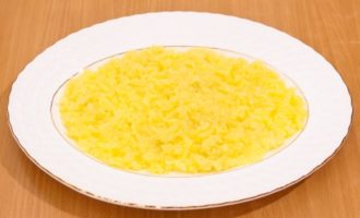 Ei bine, asta-i tot, cel mai laborios proces s-a încheiat. Acum nu mai rămâne decât să ne asamblam delicioasa salată. Heringul sub o haină de blană este asamblat din 6 straturi. Primul strat este cartofii rasi. Așezați-l pe un vas alungit, nivelați-l și faceți deasupra o plasă groasă de maioneză.