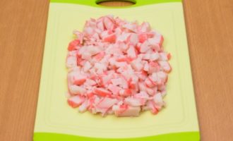Tăiați carnea de crab (sau bețișoare) în bucăți mici.