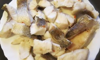 Överför försiktigt de kokta fiskbitarna till en tallrik.