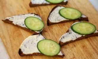 Maglagay ng hiwa ng pipino sa isang sulok ng isang hiwa ng tinapay.