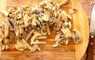Obriu el pot de bolets, aboqueu 2 culleradetes directament a la marinada.vinagre 9% i deixar reposar 20 minuts, després posar els bolets en un colador, deixar escapar la humitat, tallar els bolets a tires.
