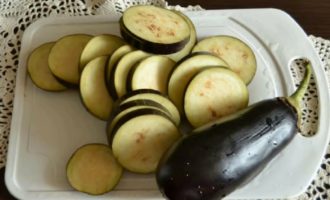 Tvätta genast auberginema och skär dem sedan i cirklar. Lägg i en djup skål och fyll med vatten. Vattnet måste saltas. Lämna auberginema i denna form i 30 minuter så att beskan kommer fram. Häll av vattnet.