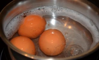 Com preparar una clàssica amanida Olivier amb botifarra i pèsols? Bullir els ous durs, per fer-ho, aboqueu-hi aigua en una cassola, afegiu-hi una mica de sal, podeu afegir una mica de refresc a l'aigua. Després de bullir, bulliu els ous exactament 10 minuts, després transferiu-los ràpidament a aigua gelada amb una cullera ranurada i deixeu-los refredar. Bulliu les patates i les pastanagues en una cassola sense pelar. Escorreu l'aigua dels pèsols i poseu-los en un colador per eliminar tota la humitat. Pesa 100 g a la balança.