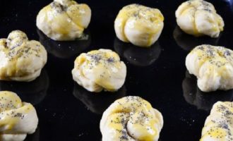 Porniți cuptorul la 180 de grade (cel mai bine este să faceți acest lucru mult mai devreme pentru a avea timp să se încălzească corespunzător). Ungeți o tavă de copt cu puțin ulei vegetal și puneți chiflele pe ea. Blatul fiecărei bucăți trebuie uns cu gălbenuș.Stropiți chiflele cu semințe de mac.