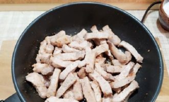 Ngayon iprito ang baboy sa pinainit na langis ng gulay upang maalis ang labis na kahalumigmigan. Timplahan ang karne at asin ito. Ipagpatuloy ang pagprito hanggang sa maging kayumanggi ang baboy.
