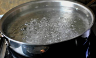 Om de inktvissalade te bereiden, doe je eerst water in een pan op het fornuis. We hebben het nodig om te koken. 