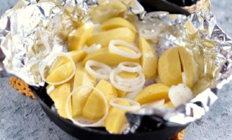 Espolvorear les patates amb sal i pebre al gust, després afegir una mica d'oli d'oliva. Peleu i piqueu els grans d'all o passeu-los per una premsa d'all i poseu-los en paper d'alumini amb les patates per donar sabor al plat. Espolvorear les patates amb sal i pebre al gust, després afegir una mica d'oli d'oliva. Peleu i piqueu els grans d'all o passeu-los per una premsa d'all i poseu-los en paper d'alumini amb les patates per donar sabor al plat.