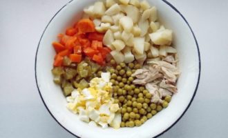 Scurgeți sucul de mazăre și turnați-l într-un castron adânc. Punem acolo si carne de pui, cartofi, oua, morcovi, castraveti, asezonam cu maioneza, amestecam, adaugam sare dupa gust. 