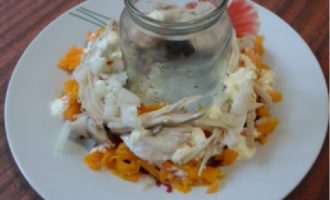 Espolvorear amb una capa de fruits secs, disposar trossos de carn, cobrir amb maionesa, espolvorear amb una mica de ceba.