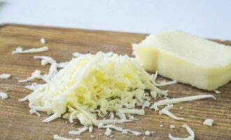 Sedan måste du förbereda fyllningen för svampen. För att göra detta, riv den valda osten på ett fint rivjärn som inte läcker (suluguni eller parmesan är idealiska val). 