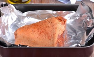 Matapos lumipas ang tinukoy na oras, alisin ang buko mula sa bag. Kung ang paprika ay na-rubd off mula sa balat sa ilang mga bahagi, pagkatapos ay kailangan mong kumuha ng kaunti pang paprika powder at kuskusin ito sa balat ng shank. Ilipat ang baboy sa isang baking dish na nilagyan ng malaking piraso ng foil.