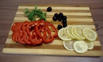 Placera den förberedda fyllningen i fiskens mage. På ett stort ark av folie, smord med vegetabilisk olja, placera den andra löken, skär i ringar. Lägg den förberedda karpen på löken och bred ut den med resten av gräddfilssåsen.