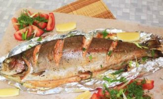 Vi tar ut den färdiga fisken och överför den tillsammans med folien till en serveringsbräda (om du inte vill att öringen ska falla sönder är det bättre att överföra den tillsammans med folien). Dekorera med örter och lägg i tomat- och citronskivor. Vi tar ut den färdiga fisken och överför den tillsammans med folien till en serveringsbräda (om du inte vill att öringen ska falla sönder är det bättre att överföra den tillsammans med folien). Dekorera med örter och lägg i tomat- och citronskivor.