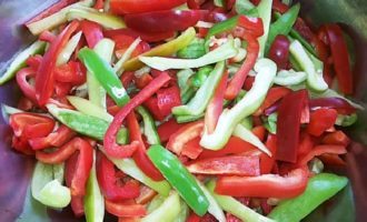 Spalam ardeii, ii taiem in jumatate, taiem tulpinile, indepartam semintele si membranele, iar pulpa taiem fasii mici.Puneți ardeii tăiați într-o cratiță cu amestecul de roșii și fierbeți legumele la foc mediu.