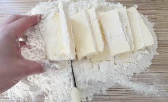 Dùng dao sắc và không chạm tay vào thức ăn, cắt bơ thực vật thành từng miếng trong khi trộn với bột mì.