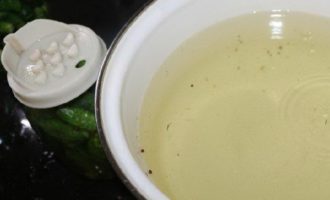 După acest timp, turnați apa din borcan printr-un capac special (cu găuri) într-o cratiță mică și puneți-o la foc mediu. Turnați cantitatea de sare și zahăr specificată în rețetă într-o cratiță și gătiți marinada timp de câteva minute. Opriți focul și turnați esența de oțet în marinadă.